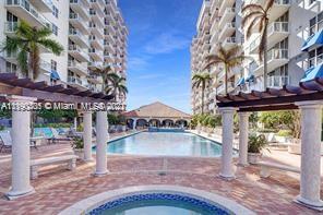 5077 Northwest 7th Street, Unit 1402 Miami, FL 33126 - Photo 13 of 87 a view of a large building with a big yard and large trees