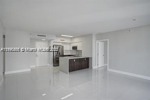 5077 Northwest 7th Street, Unit 1402 Miami, FL 33126 - Photo 49 of 87 a kitchen with stainless steel appliances a refrigerator and wooden cabinets
