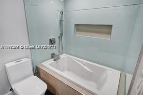 5077 Northwest 7th Street, Unit 1402 Miami, FL 33126 - Photo 63 of 87 a white bath tub sitting next to a white toilet