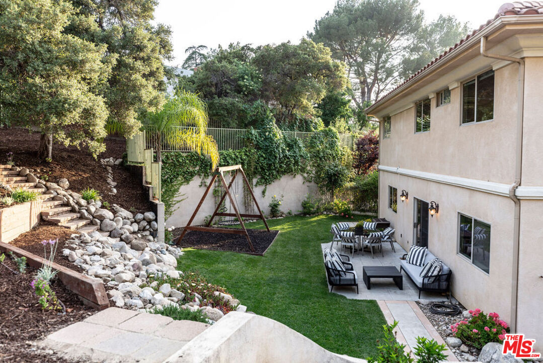 7634 Rocky Mountain View Road Tujunga, CA 91042 - Photo 45 of 50 a view of a backyard with couches potted plants and a large tree
