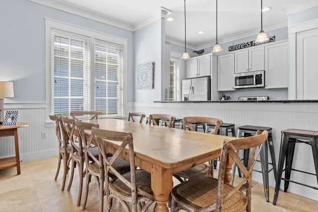 a kitchen with granite countertop a table chairs stove and microwave