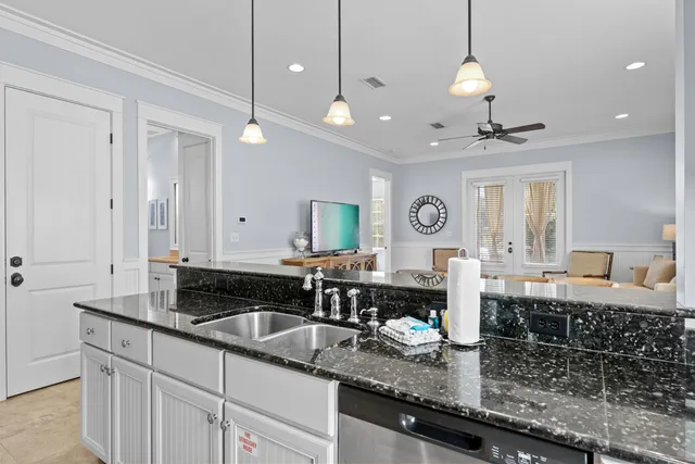 a kitchen with granite countertop a sink a stove and cabinets