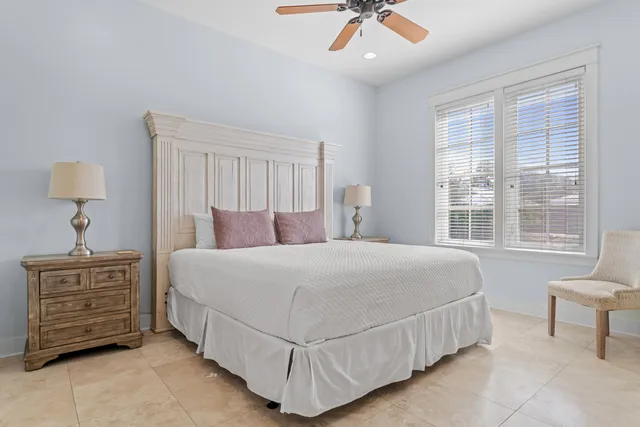 a bedroom with a bed a chandelier and a window