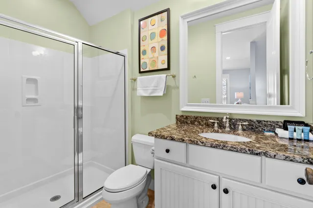 a bathroom with a granite countertop sink toilet and shower