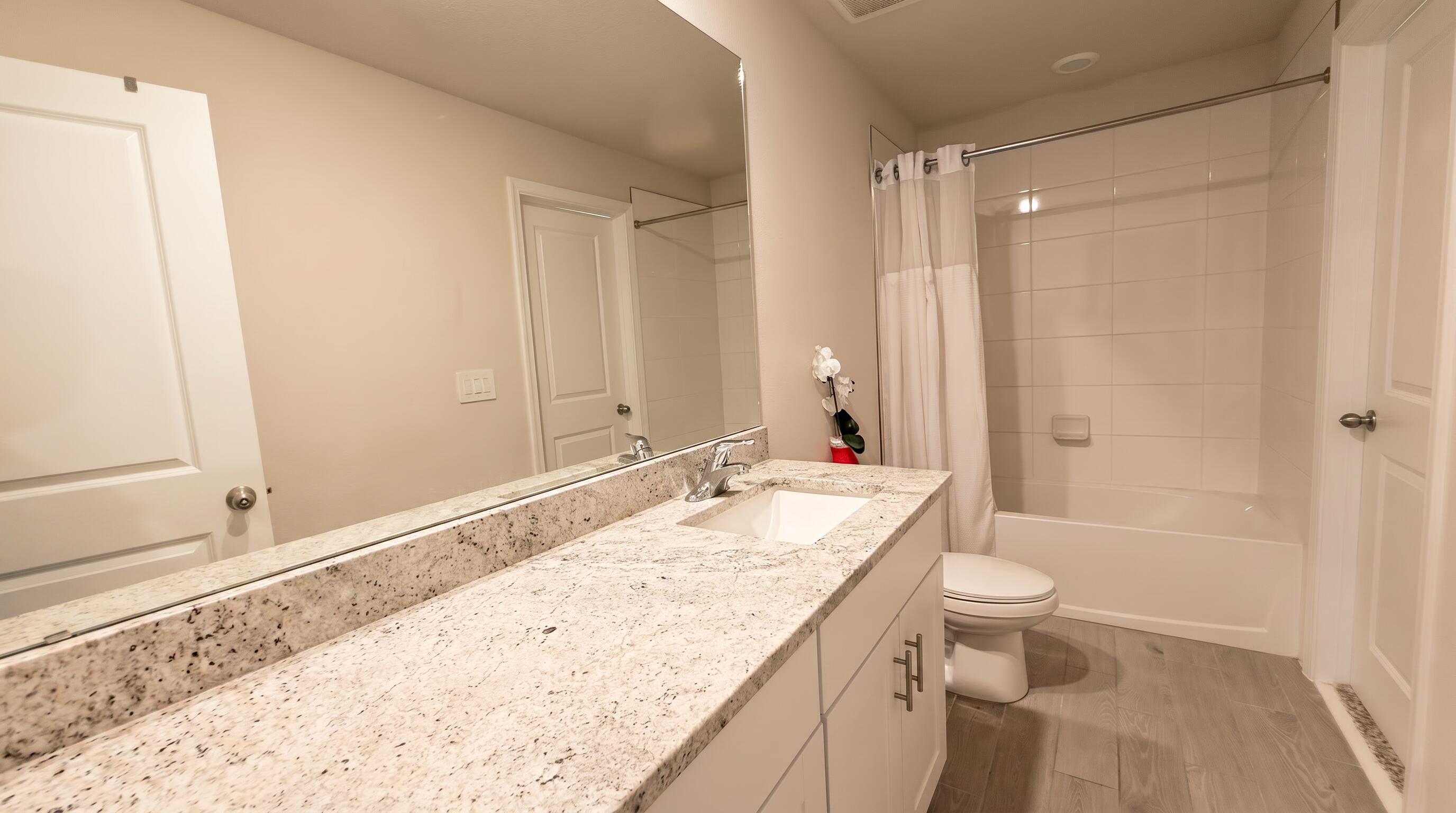 5784 Southeast Edgewater Circle Stuart, FL 34997 - Photo 13 of 33 a bathroom with a granite countertop sink a toilet and shower