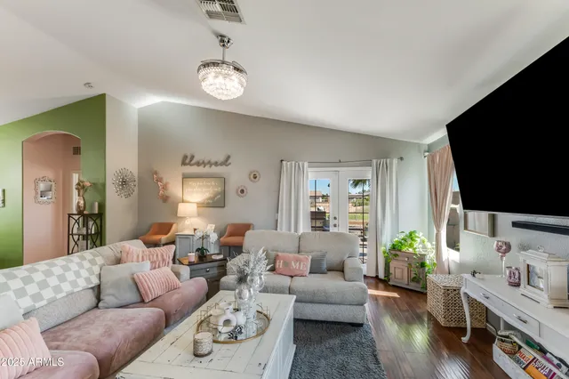 a living room with furniture a flat screen tv and a large window