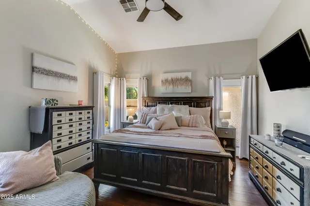 a bedroom with a bed and a flat tv screen on a dresser