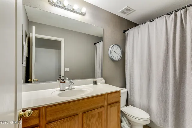 a bathroom with a sink vanity mirror and toilet