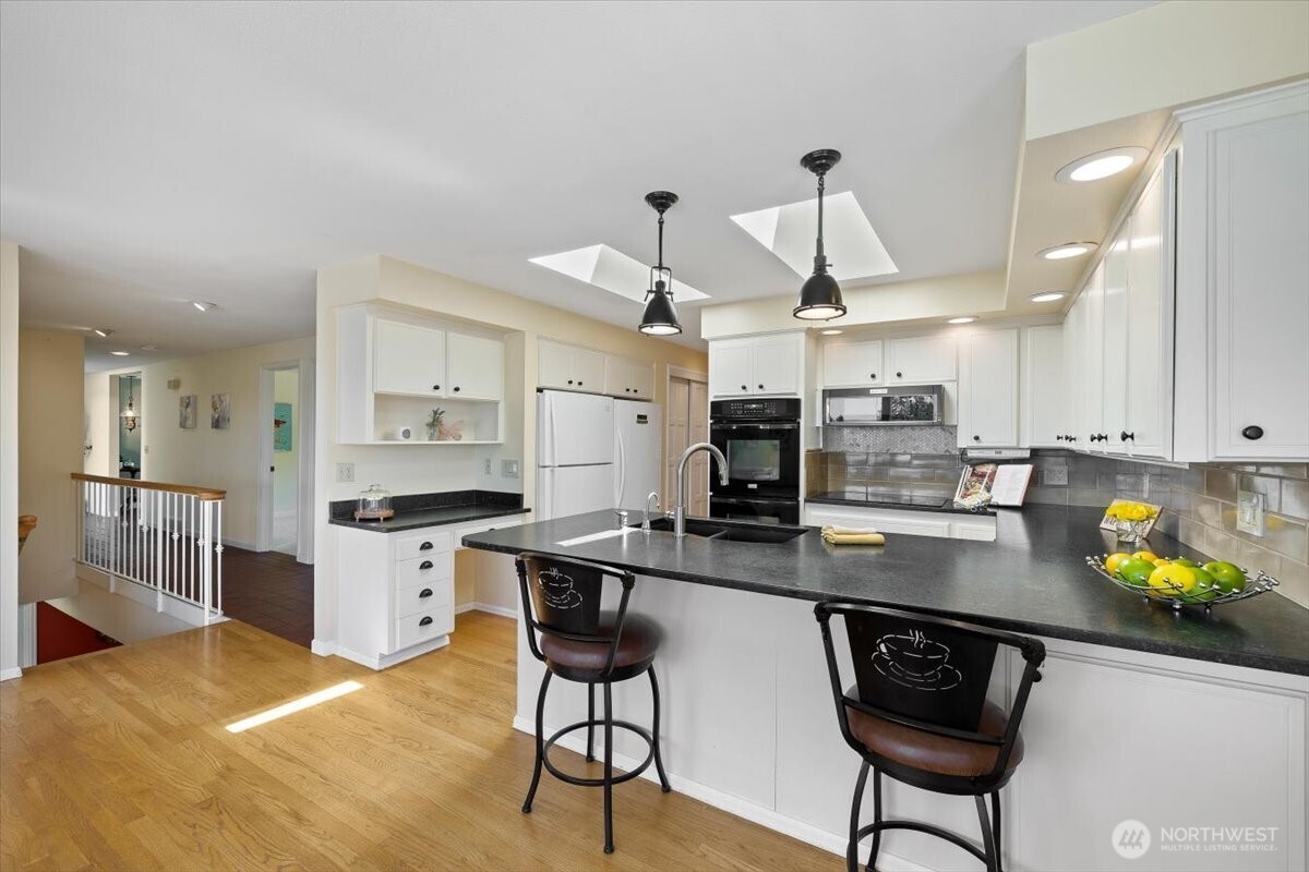 2606 49th Place Southwest Everett, WA 98203 - Photo 11 of 37 a kitchen with stainless steel appliances kitchen island granite countertop a stove a sink and a refrigerator