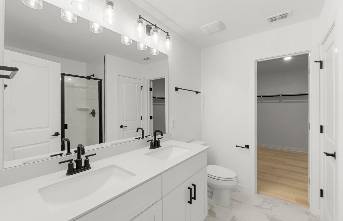 360 Begonia Street Buda, TX 78610 - Photo 13 of 26 a bathroom with a sink a toilet and shower