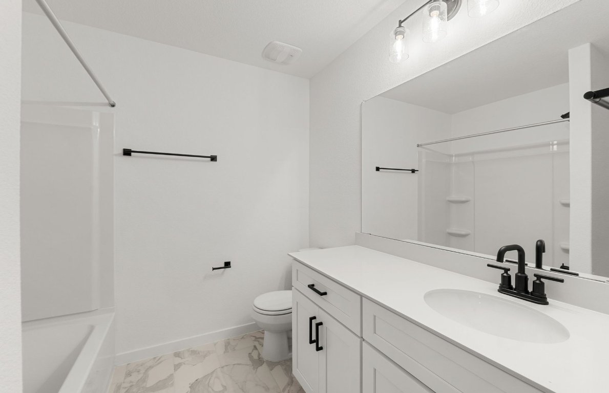 360 Begonia Street Buda, TX 78610 - Photo 18 of 26 a bathroom with a sink toilet and shower