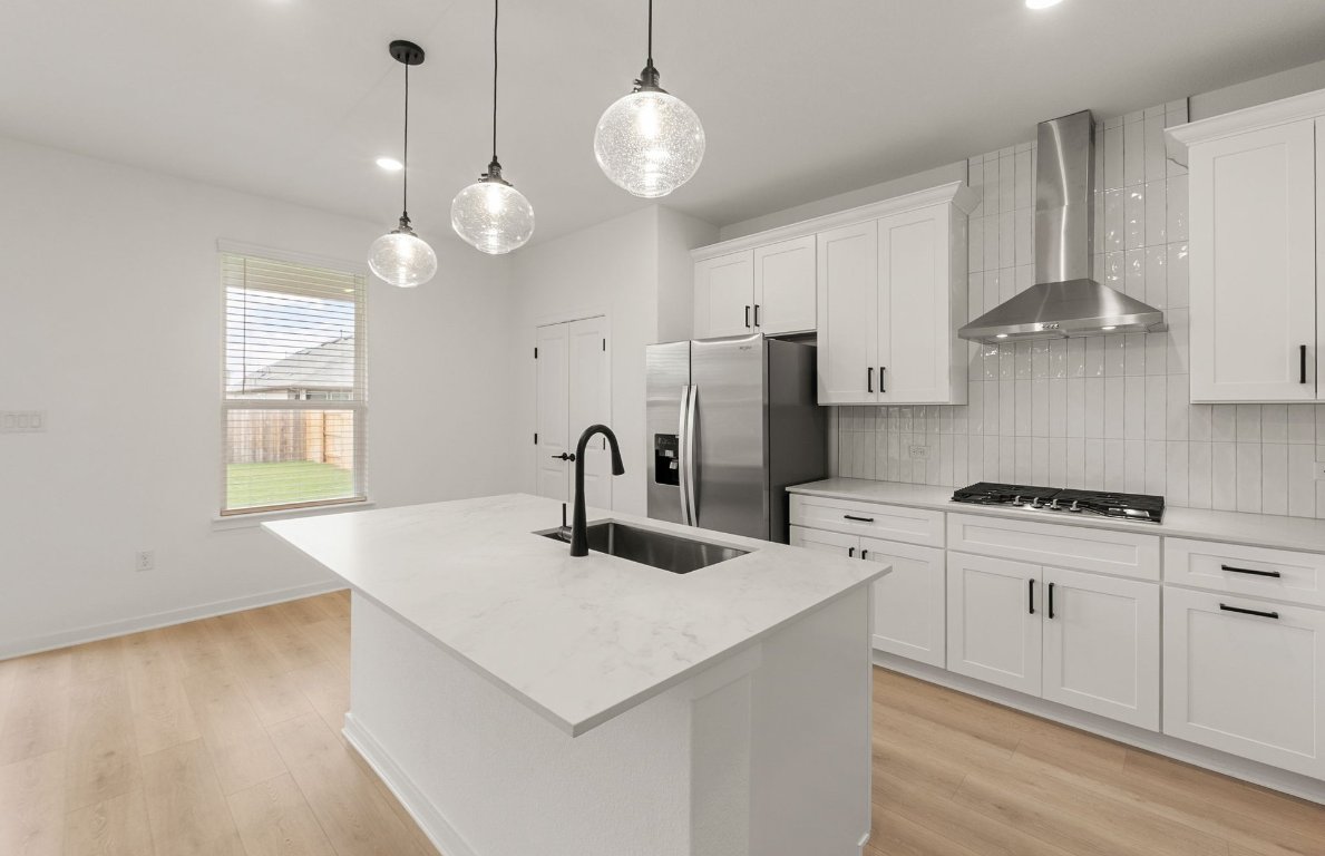 360 Begonia Street Buda, TX 78610 - Photo 4 of 26 a kitchen with stainless steel appliances granite countertop a sink a stove a refrigerator cabinets and living room view