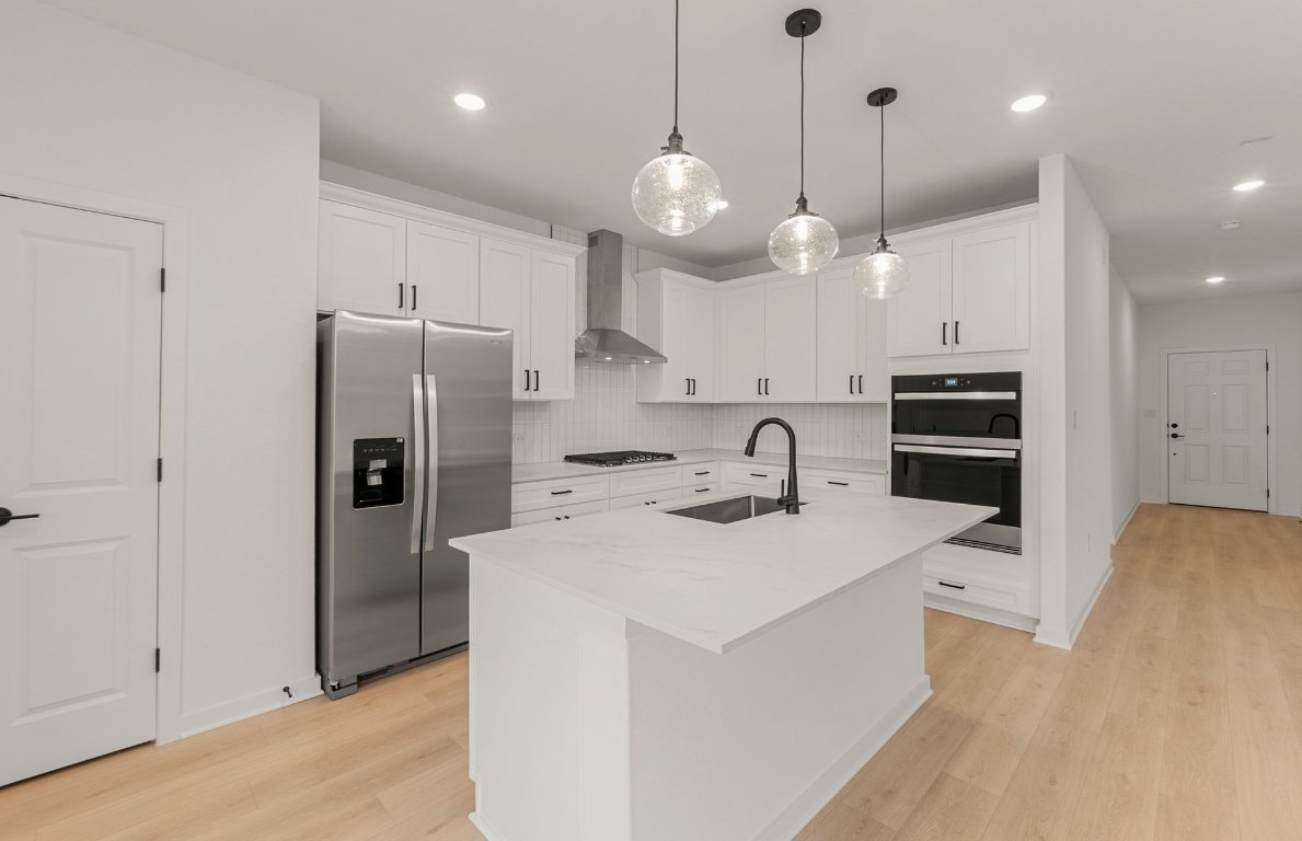 360 Begonia Street Buda, TX 78610 - Photo 5 of 26 a kitchen with stainless steel appliances a stove a refrigerator a sink and a oven