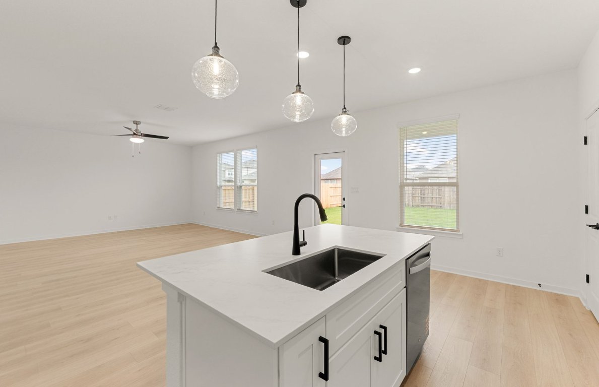 360 Begonia Street Buda, TX 78610 - Photo 7 of 26 a kitchen with stainless steel appliances granite countertop a sink a counter space and a window