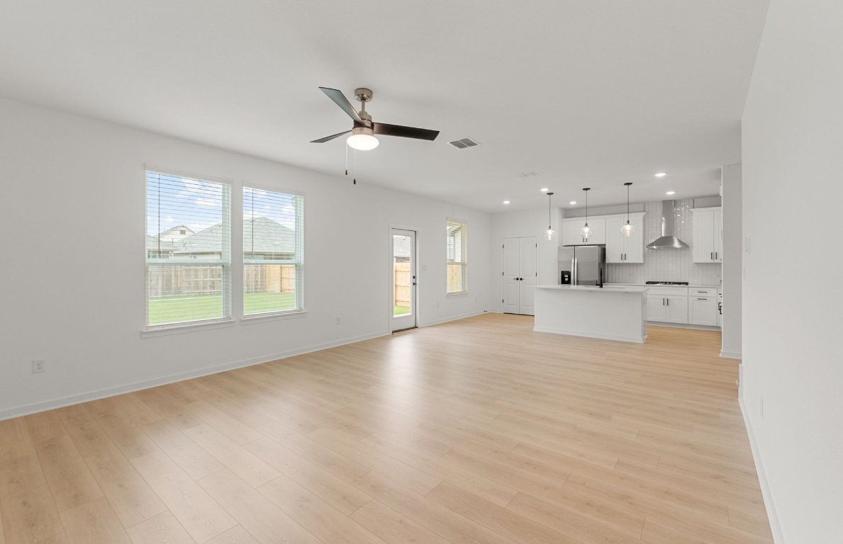 360 Begonia Street Buda, TX 78610 - Photo 8 of 26 a view of an empty room with kitchen appliances and a window