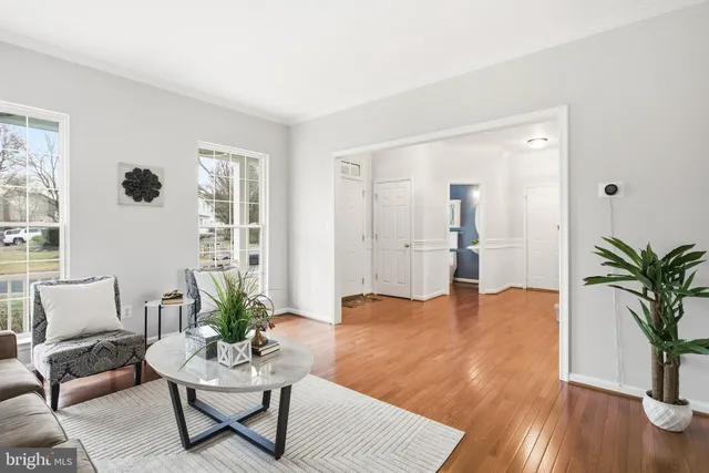 a kitchen with stainless steel appliances a dining table chairs a refrigerator and cabinets