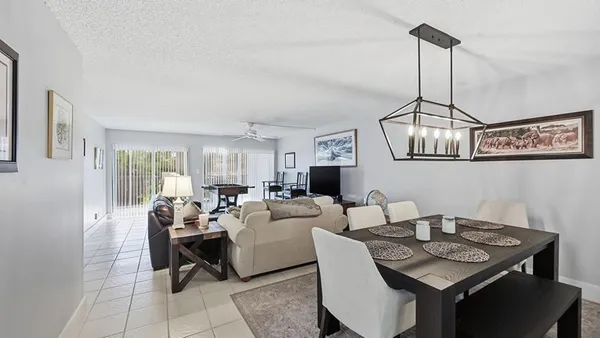a kitchen with stainless steel appliances granite countertop a dining table chairs and white cabinets