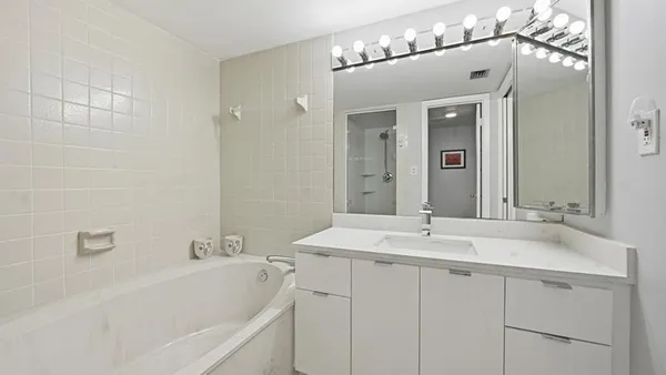 a bathroom with a sink vanity granite shower and a mirror