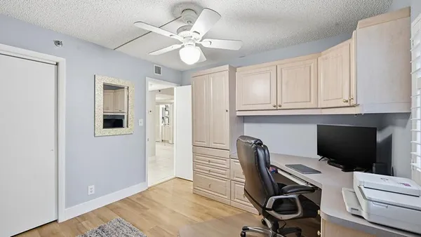 a view of a workspace with furniture and a window