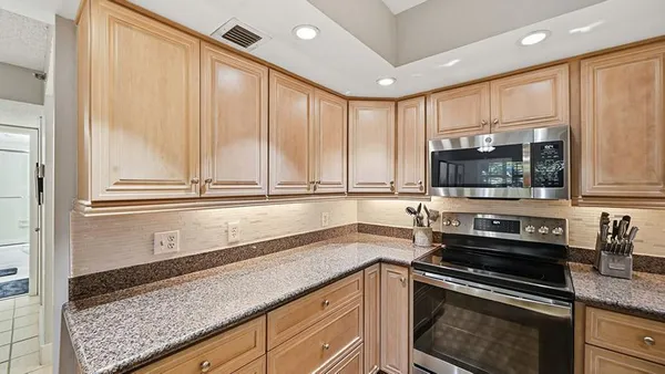 a kitchen with stainless steel appliances granite countertop a sink a stove and a microwave