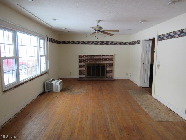 3102 State Road Vermilion, OH 44089 - Photo 15 of 45 Unfurnished living room with wood-type flooring, a brick fireplace, and ceiling fan