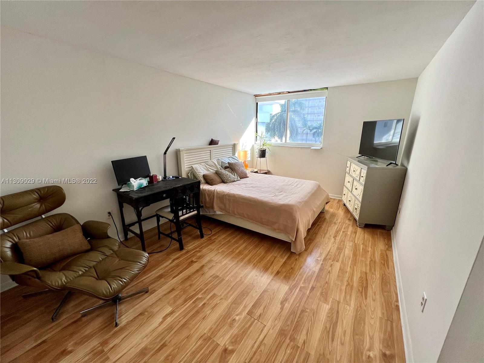 1665 Bay Road, Unit 517 Miami Beach, FL 33139 - Photo 13 of 26 a bedroom with a bed and wooden floor