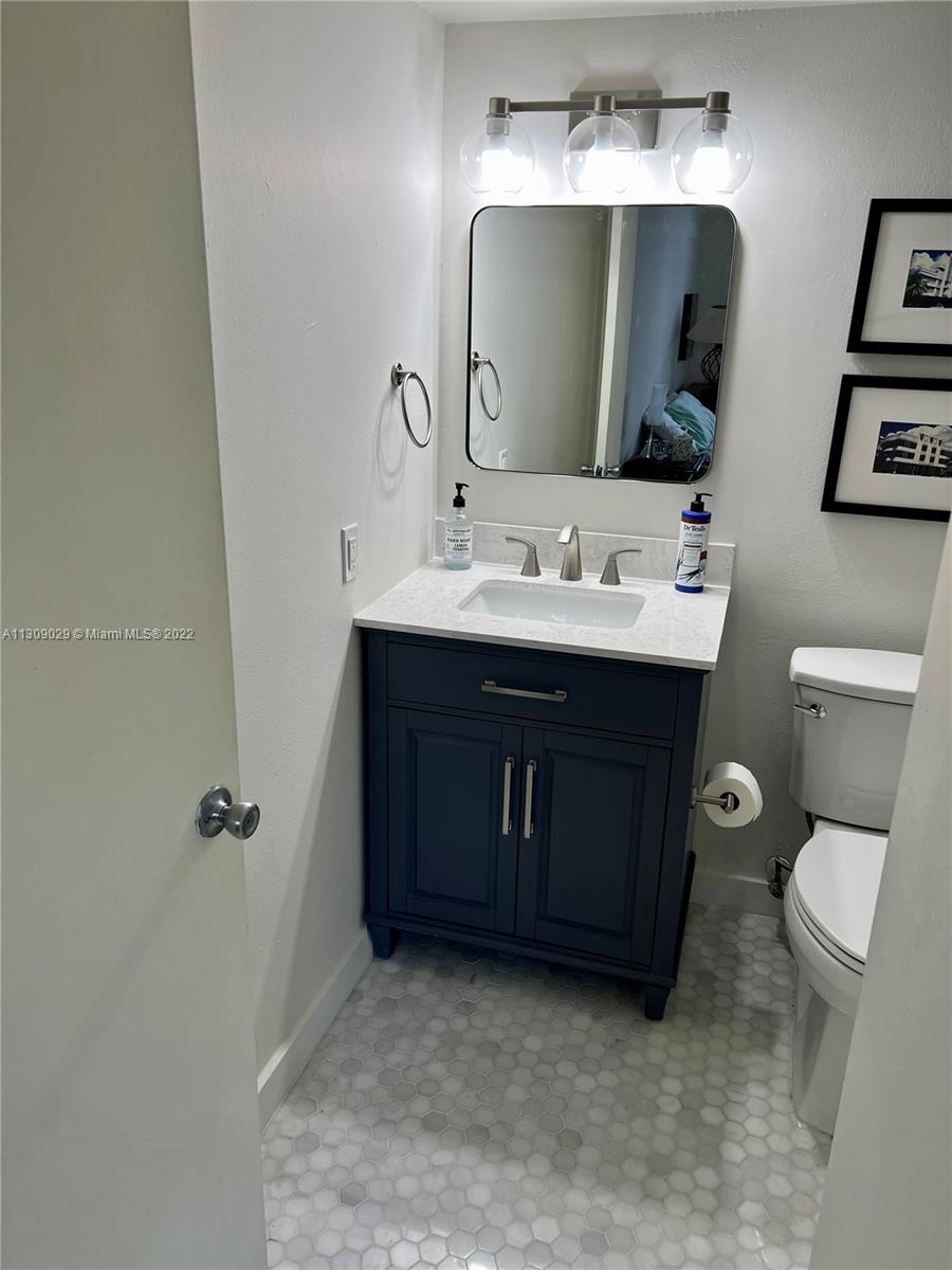 1665 Bay Road, Unit 517 Miami Beach, FL 33139 - Photo 3 of 26 a bathroom with a toilet sink and mirror