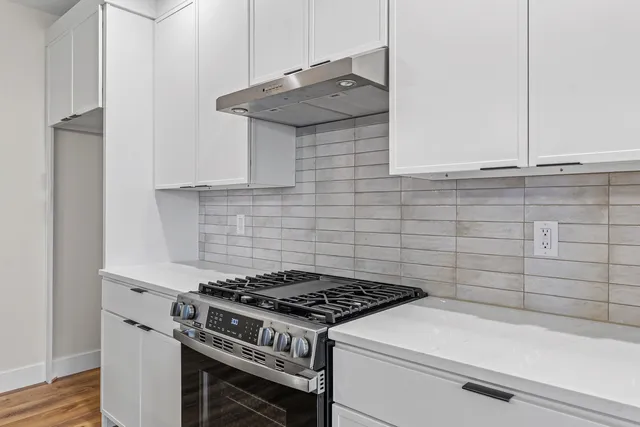 a stove top oven sitting inside of a kitchen