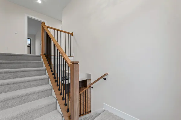 a view of staircase with railing and white walls