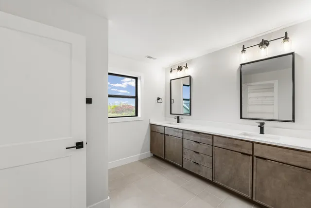 a bathroom with 2 sink tub and a mirror