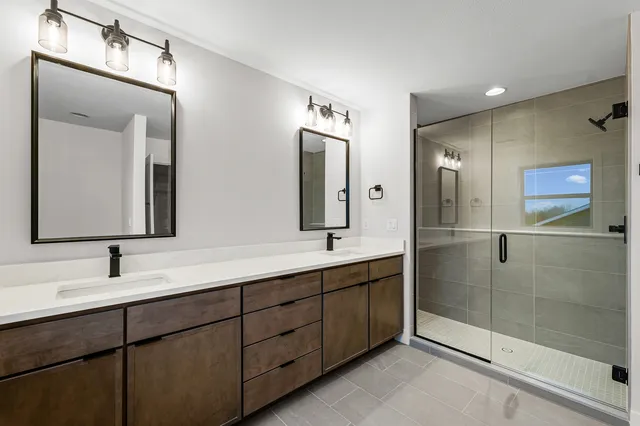 a bathroom with double sink and a mirror