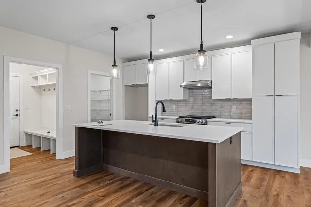 a kitchen with kitchen island a sink stainless steel appliances and cabinets