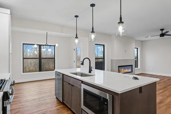 a kitchen with a sink a counter space appliances and cabinets