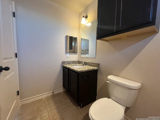a bathroom with a sink vanity mirror and toilet