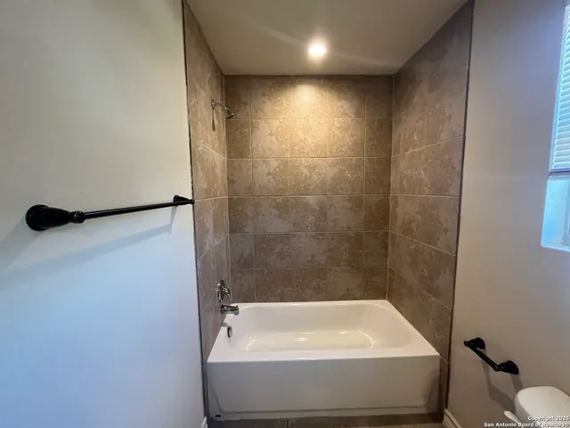 a bathroom with a tub and toilet