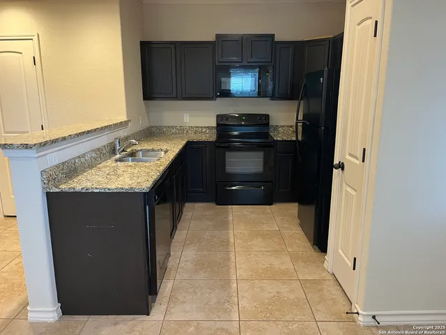 a kitchen with kitchen island granite countertop cabinets and refrigerator