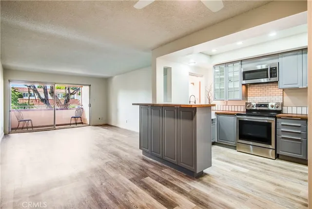 a view of a kitchen with stainless steel appliances granite countertop a stove and a sink