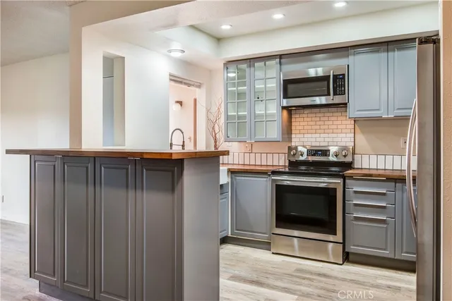 a kitchen with stainless steel appliances granite countertop a stove microwave and refrigerator
