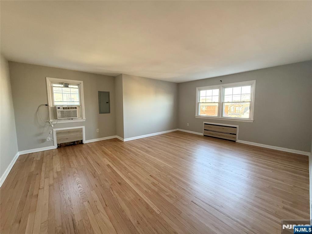175 Van Winkle Street, Unit 2 East Rutherford, NJ 07073 - Photo 4 of 20 an empty room with wooden floor and windows