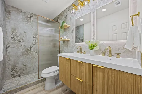 a bathroom with a sink toilet and shower