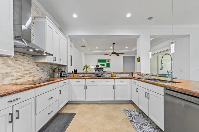 a kitchen with granite countertop white cabinets and stainless steel appliances