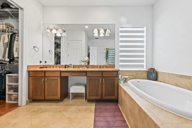 a bathroom with a granite countertop sink a mirror and a bathtub