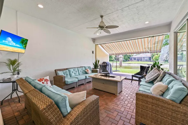 a living room with furniture potted plant and a large window