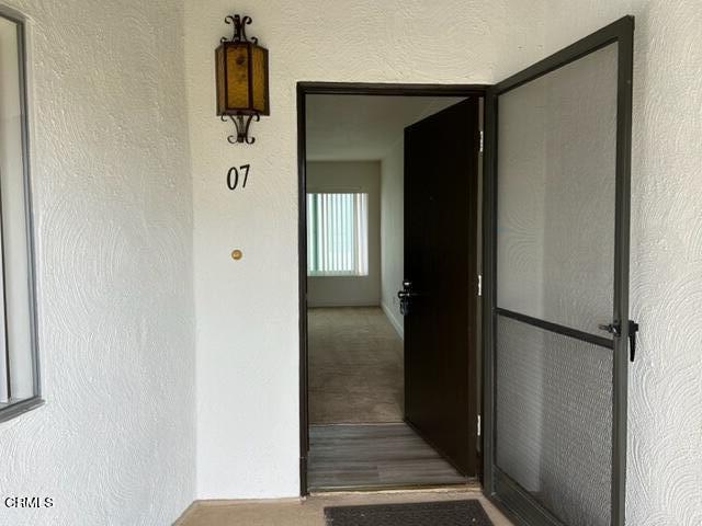 a view of a hallway with wooden floor