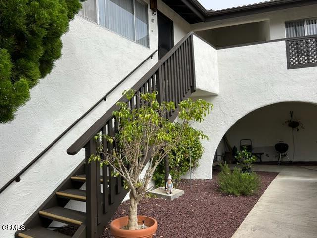 4907 Dunes Street, Unit 7 Oxnard, CA 93035 - Photo 52 of 74 a vase of flowers sitting on a floor next to a white house