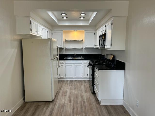 4907 Dunes Street, Unit 7 Oxnard, CA 93035 - Photo 10 of 74 a kitchen with stainless steel appliances granite countertop a refrigerator a stove a sink and white cabinets with wooden floor