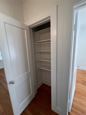 a view of walk in closet with wooden floor