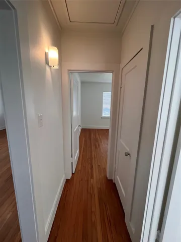 a view of a hallway with wooden floor
