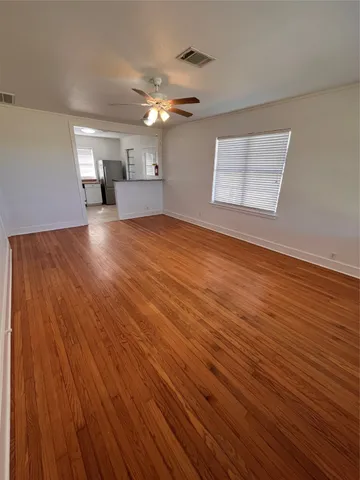 a view of empty room with wooden floor