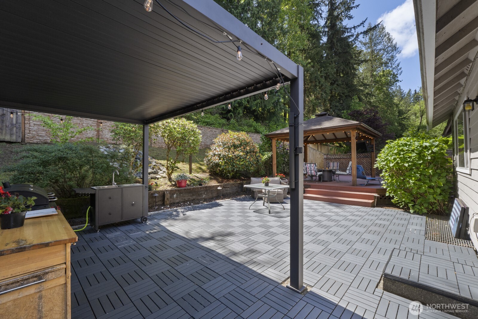 6108 133rd Place Southwest Edmonds, WA 98026 - Photo 3 of 40 a view of a patio with table and chairs potted plants with wooden floor and fence